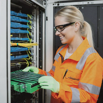 Woman working at optic fibre patch panel
